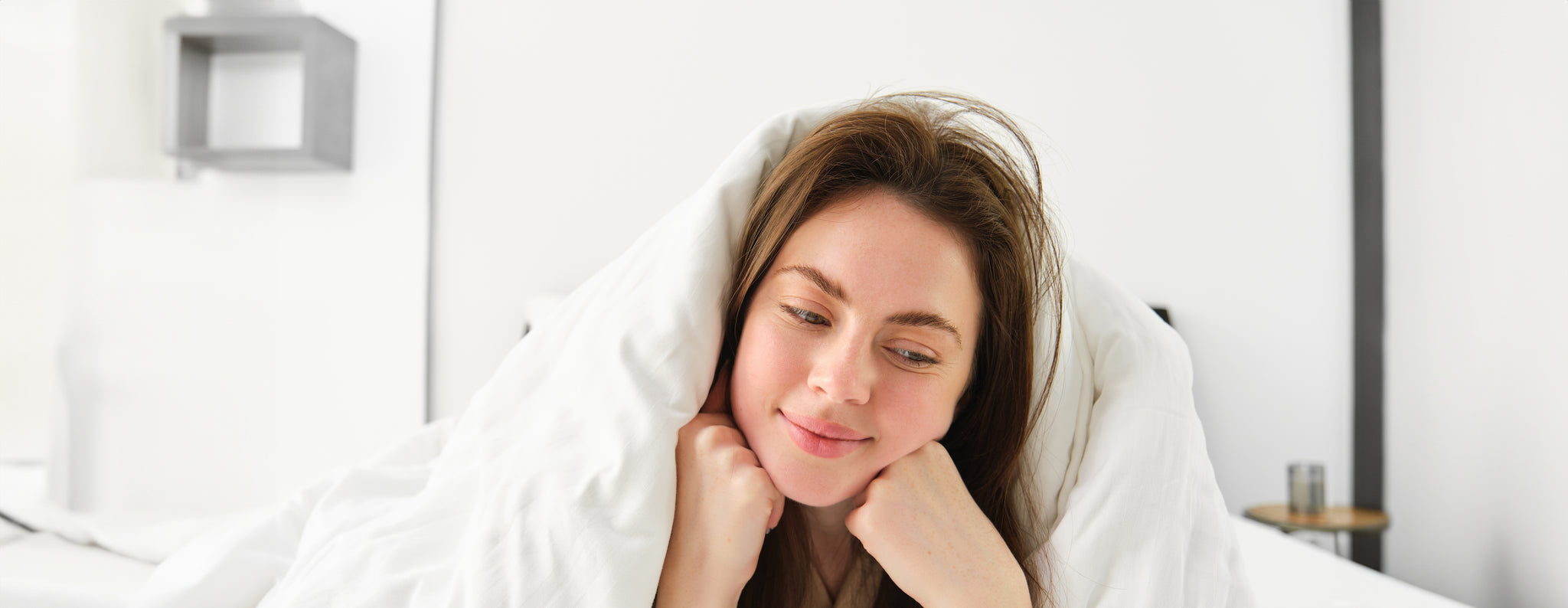 a happy lady smiling while lying on the hygiene mattress 