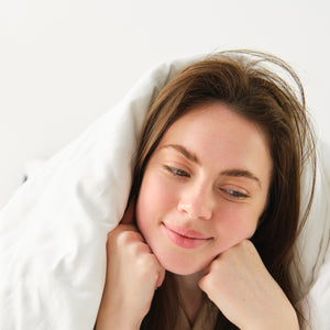 a happy lady smiling while lying on the hygiene mattress 